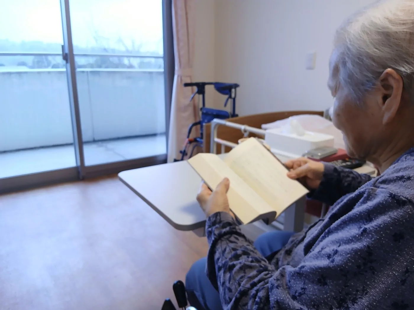 窓辺の明るい個室で読書を楽しむご入居者様のイラスト